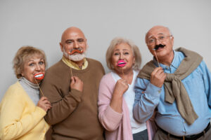 A group of senior friends participating in one of the fun activities for seniors and celebrating together at a party with joyful expressions. The scene captures warmth, laughter, and companionship in a cheerful indoor setting.
